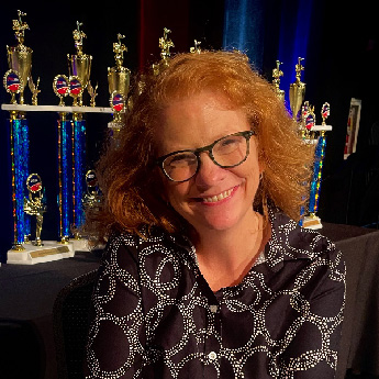 Photo of Susan L. Smith, trophies on display in the background.